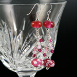 Top bead is Cranberry Pink over clear; bottom beads are Cranberry Pink over a base of white and decorated with white stringer