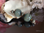 CiM Porpoise spacers; 2 main beads are Effetre black 064 with Porpoise and TAG Fire Lotus