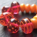 CiM Cranberry Pink encased with Effetre Super (Crystal) Clear 006 with CiM Alley Cat decoration and spacers
