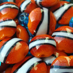 Effetre Orange 422 with Thompson Bright Red enamel. CiM Foam and CiM Hades bands. Spacers are Effetre transparent Dark Aqua 036.