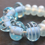 CiM Zachary encased with Effetre transparent Pale Aquamarine 038, with Effetre White 204 decoration. Spacers are Effetre 038 coated with silver mica.