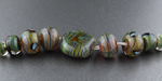 "This is Pink Pansy pulled into frit stringer using my random blend of TAG and Double Helix reduction colours. I've put it over a core of Pink Pansy in most of the beads, which is why you can see a lot of pink poking through."