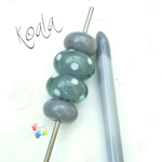 Larger beads are a base of Koala, encased in Effetre steel grey and decorated with Peace polka dots. Smaller ones are plain Koala.